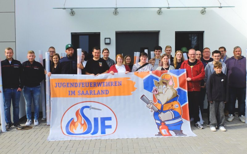 Das Bauzaunbanner zeigt Maskottchen Eberhard im Look der Saarländischen Jugendfeuerwehr