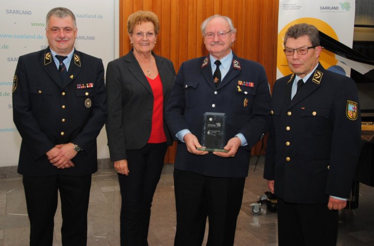 Ministerin Monika Bachmann übergibt den Preis an den Kreisfeuerwehrverband Saarlouis, vertreten durch Bernd Paul, Brandinspekteur und Vorsitzender des Kreisfeuerwehrverbandes und Helmut Engeldinger, Geschäftsführer, im Beisein von Landesbrandinspekteur Bernd Becker.