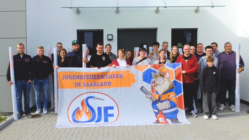 Das Bauzaunbanner zeigt Maskottchen Eberhard im Look der Saarländischen Jugendfeuerwehr